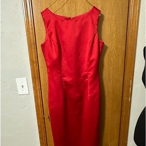 Full length, sleeveless red sheath dress.